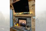 Cozy fireplace with a large flat screen TV. 